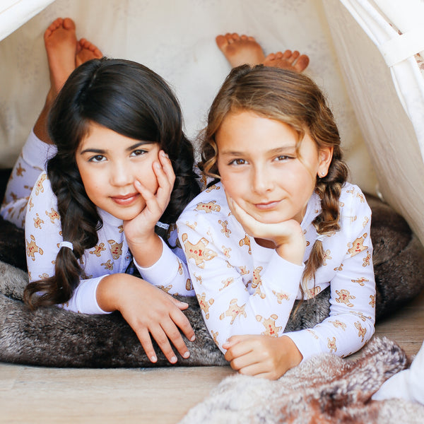 two toddler girls wearing gingerbread men print family pajamas